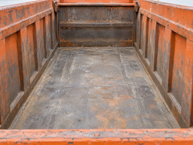 Interior de la caja de carga de un camión volquete HOWO, mostrando el ancho interior y la altura de costado para el volumen de carga